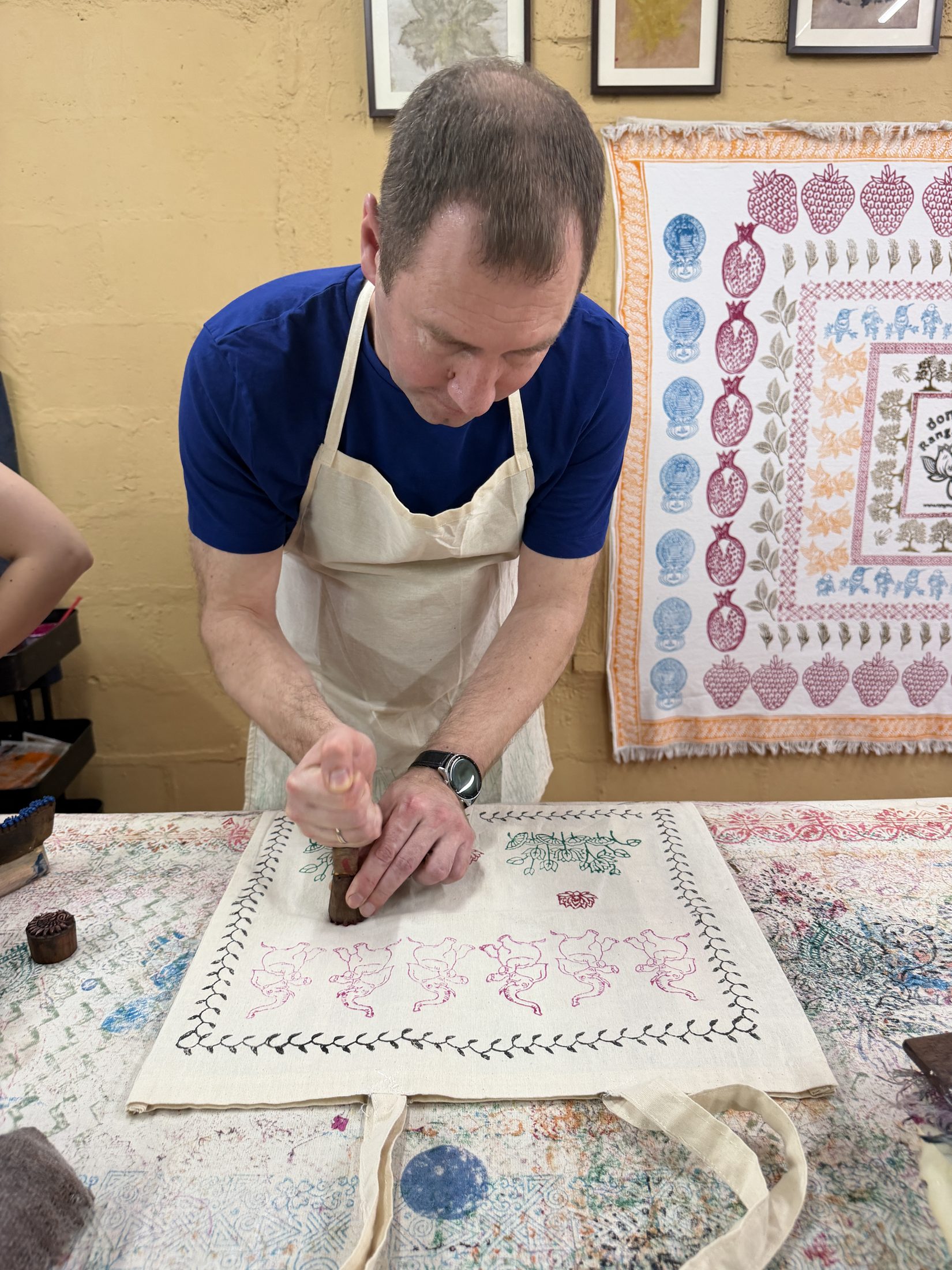Artisan demonstrating block printing technique on natural fabric